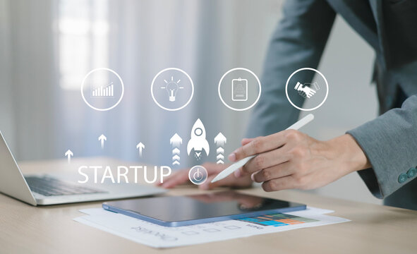 The startup business concept using a digital tablet virtual screen includes an activation icon and organizational growth strategy.