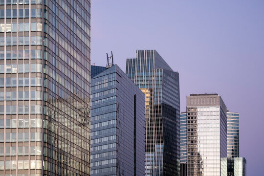 Skyscrapers and office buildings in Paris form an urban skyline with glass facades and geometric windows across the modern financial district