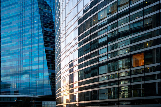 Glass facade office building in Paris layers blue reflections across modern architecture with windows and geometric lines shaping the city