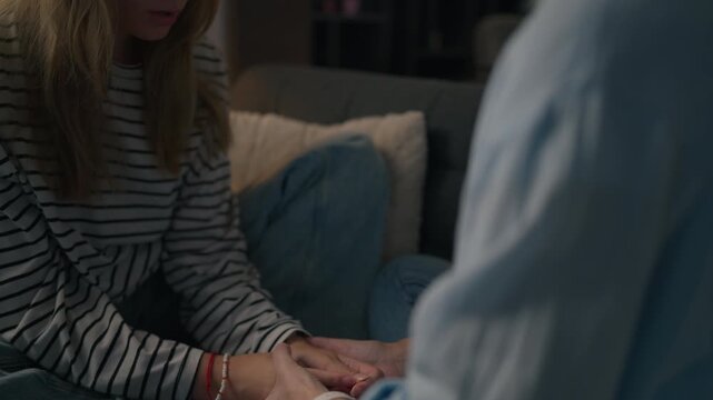 Close-up of a mother gently holding her daughter's hands, offering comfort, empathy, and unconditional love during a difficult conversation, showing trust, support, and a strong family bond
