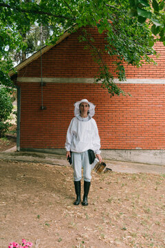 Bee farming. Female beekeeper prepares for the bee inspection