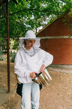 Bee farming. Female beekeeper prepares for the bee inspection