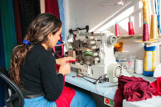 Woman sewing with industrial machine in studio
