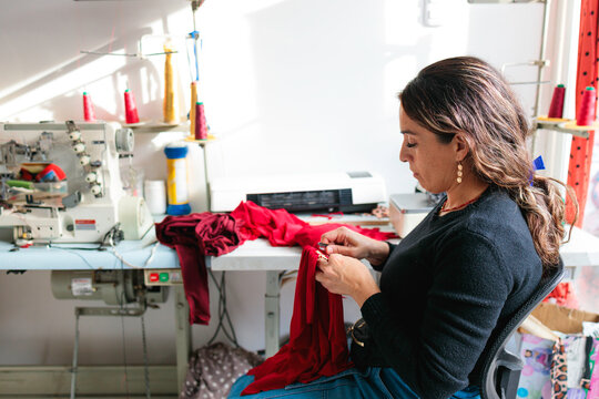 Woman sewing fabric in workshop