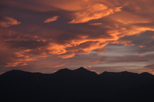 Dramatic sunset sky above alpine mountains near Lake Garda