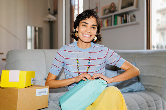 Woman receiving packages at home enjoying online shopping ugc