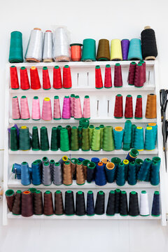 Colorful sewing spools on shelves