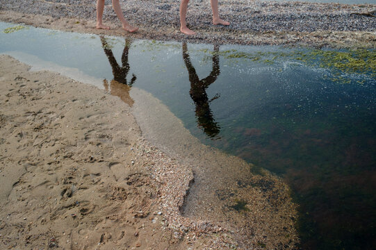 Two women walking through shallow water