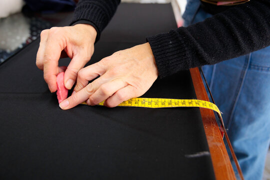 Woman marking dark fabric with chalk