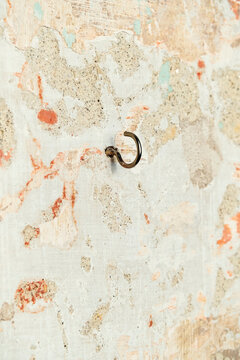Rusty Metal Hook on a Textured Wall With Peeling Paint