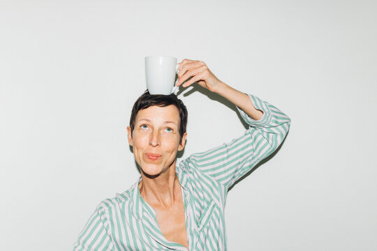 Woman Balancing Coffee Mug on Head
