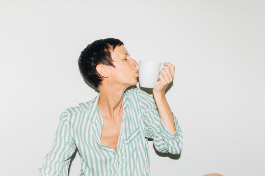 Woman Kissing Coffee Mug at Home