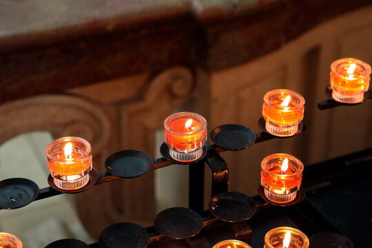 Small candles burn as votive offerings during a church prayer
