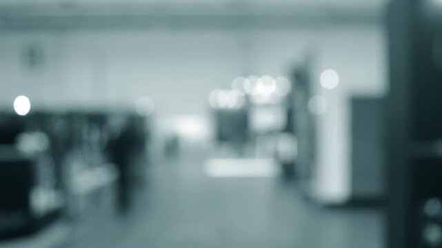Blurred background. Many people walking inside large building. Men and women walking on floor inside room with high ceiling and large lanterns on walls. Public place. Exhibition presentation backdrop