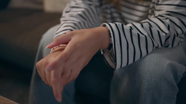 Close-up of teenage girl's hands cracking her fingers, showing nervous habits, stress, emotional tension and discomfort during a moment of anxiety.