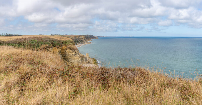 Arromanches-les-Bains, France - 08 10 2026: Coastal path. Panoramic view of the cliffs, the sea and cloudy sky from top of the path