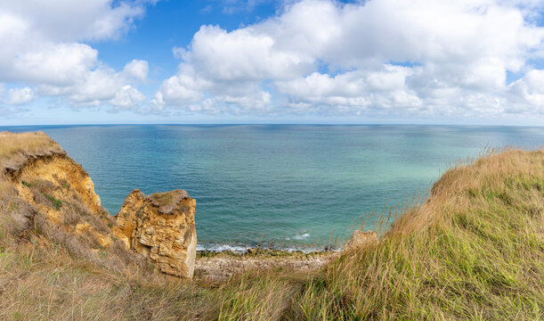 Arromanches-les-Bains, France - 08 10 2026: Coastal path. Panoramic view of the cliffs, the sea and cloudy sky from top of the path