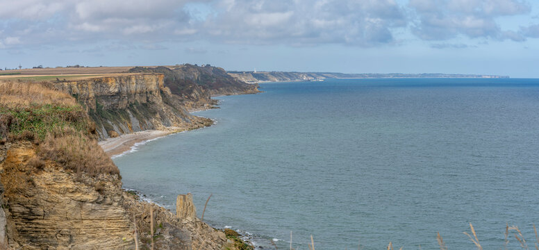 Arromanches-les-Bains, France - 08 10 2026: Coastal path. Panoramic view of the cliffs, the sea and cloudy sky from top of the path