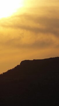 A dramatic sunset over the silhouetted hills of Opoul Perillos, France, vertical 9:16 view.