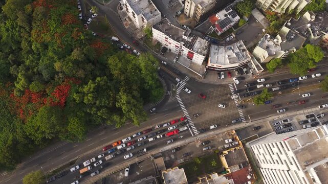 Aerial view of Avenida de los Proceres intersection with heavy traffic and lush green trees in Santo Domingo, Distrito Nacional, Dominican Republic.