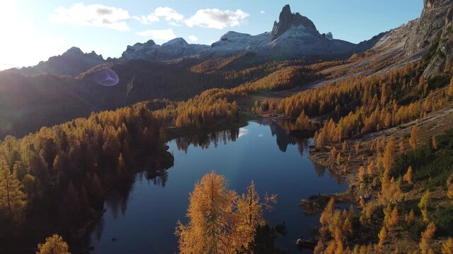 Aerial view of Lago Federa surrounded by golden larch trees and mountain peaks in Cortina d'Ampezzo, Veneto, Italy.
