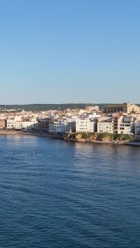Vertical 9:16 video showing the scenic coastline of L'Escala, Spain. The shot highlights the charm of this Costa Brava town. No people are visible in the frame.