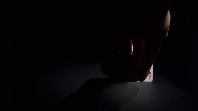 A hand places chips next to a pair of aces. Concept of luck, risk, gambling, strategy and winning hand.