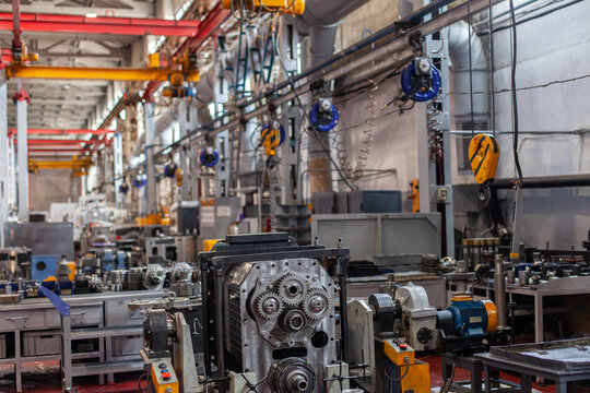 Industrial interior of modern tractor manufacturing plant. Assembly line, mechanical components, heavy-duty machinery. Technological progress, automation, manufacturing process, mechanical engineering