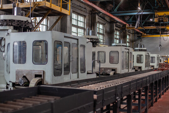 Industrial tractor manufacturing assembly line in heavy machinery factory. Engineering, automation, industrial development, large-scale manufacturing processes.
