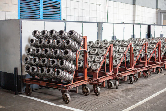 Industrial metal gear parts on carts at tractor manufacturing plant. industrial efficiency, precision engineering, mass production. Heavy industry, factory operations, engineering supply chains.