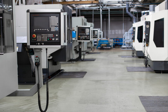 CNC machines in row at modern industrial tractor factory. Advanced industrial automation, precision engineering, efficiency of modern machinery.