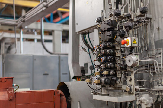 Close-up of industrial hydraulic control system in tractor manufacturing plant. Industrial automation, heavy machinery manufacturing, engineering precision.
