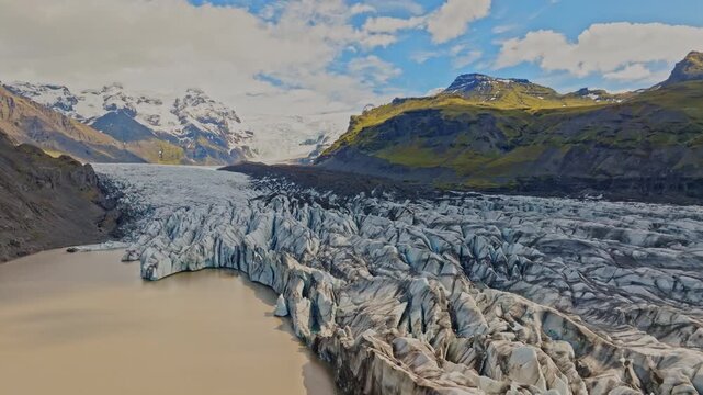 Cinematic aerial flight above the spectacular glacier front of Fjalls&aacute;rl&oacute;n Glacier Lagoon in Iceland, revealing deep crevasses, blue glacial ice and the dramatic landscape of Vatnaj&ouml;kull.