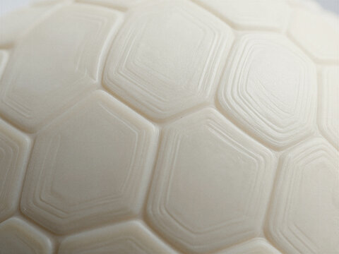 Macro view of white ivory tortoise shell texture showcasing intricate hexagonal geometric patterns