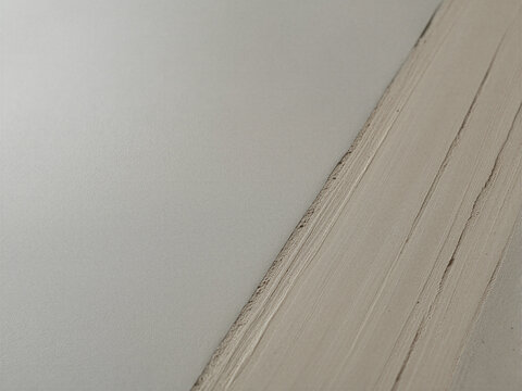 Stacked plasterboard panels featuring rough textured edges and smooth gray surfaces