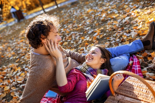 Romantic parents holding a book on autumn picnic