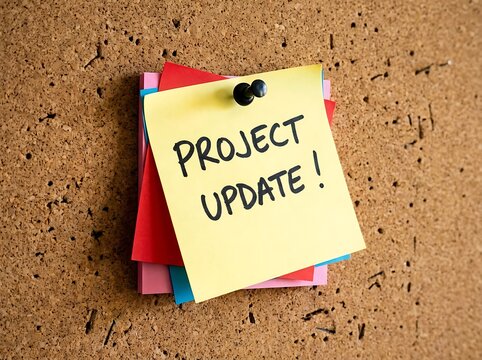 Colorful paper envelope with project update text on wooden surface