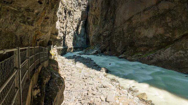 Grindelwald Glacier Canyon timelapse of rushing river waters flowing through narrow rock gorge between steep cliffs in Switzerland