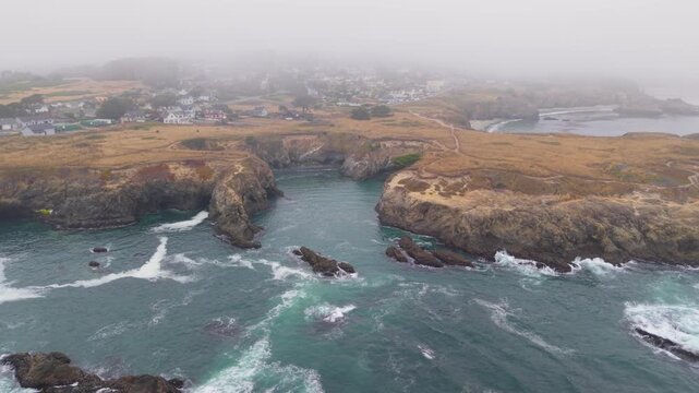 Aerial views show the town of Mendocino California on a foggy day, highlighting the coastal trail and rugged landscape