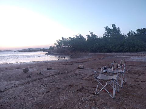 Foldable Camping Chairs Overlooking Coastal Bay at Sunset