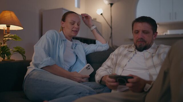 Woman trying to look at her partner's smartphone as he pushes her hand away, illustrating relationship conflict, privacy concerns, jealousy, distrust and communication problems.