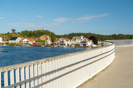 View of the modern pedestrian bridge overlooking the colorful wooden houses and waterfront of the coastal town of Mandal, Agder, Norway.