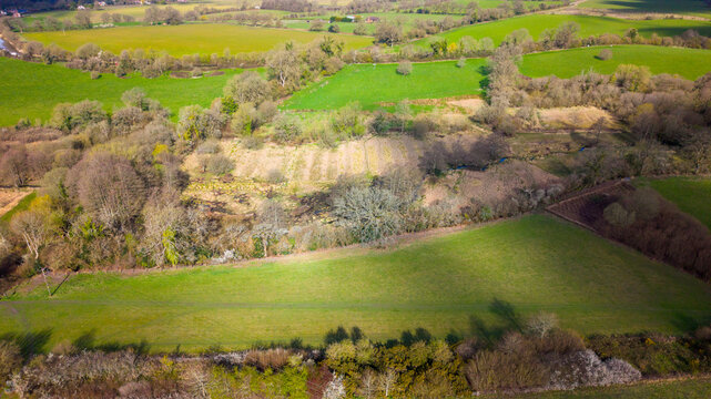 Aerial view of the lush green fields and hedgerows of the Vale of Pewsey, characterized by rolling chalk downland and rural landscape in Pewsey, Wiltshire, United Kingdom.