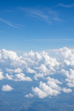 White, puffy clouds against a blue sky from an airplane
