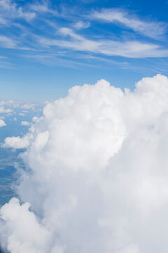 White, puffy clouds against a blue sky from an airplane