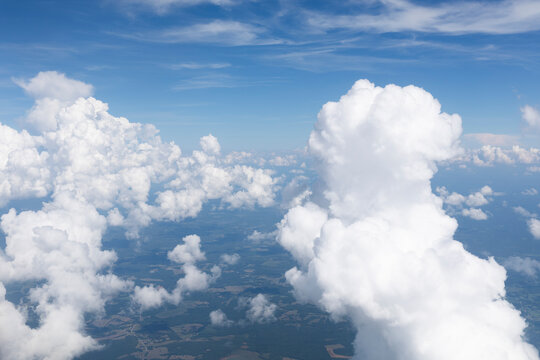 White, puffy clouds against a blue sky from an airplane