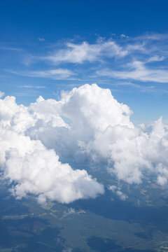White, puffy clouds against a blue sky from an airplane