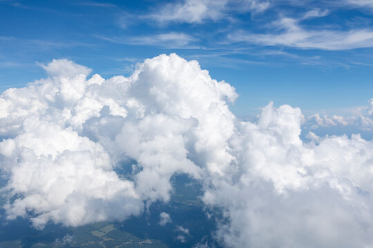 White, puffy clouds against a blue sky from an airplane