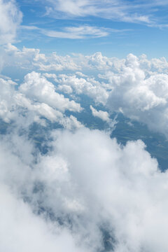 White, puffy clouds against a blue sky from an airplane