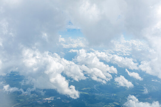 White, puffy clouds against a blue sky from an airplane